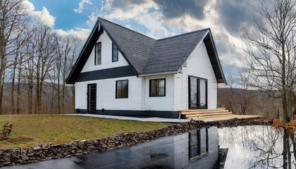 Modern white house with black accents nestled in serene nature under a cloudy sky in the countryside