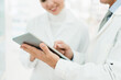 © InsideCreativeHouse - Closeup cropped shot of two female and male chemists pharmacists druggists using digital tablet for selling medicines, pills, remedies, learning new goods side effects in pharmacy drugstore