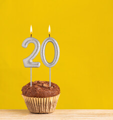 Poster - Number 20 birthday candle - Chocolate cupcake on a yellow background.