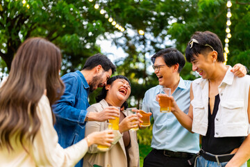 Group of Happy Asian millennial generation people friends enjoy and fun toasting beer glasses celebration reunion meeting at outdoor dinner party in the garden at restaurant on holiday vacation.