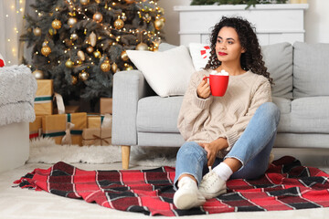 Beautiful African-American woman with cocoa celebrating New Year at home