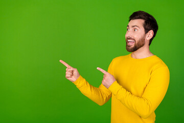 Wall Mural - Photo portrait of attractive young man point look empty space dressed stylish yellow clothes isolated on green color background