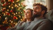 © lisbeth - Young Caucasian couple relaxing on the sofa watching Christmas movies together, eagerly awaiting Christmas and celebrating New Year 2025 in a cozy atmosphere