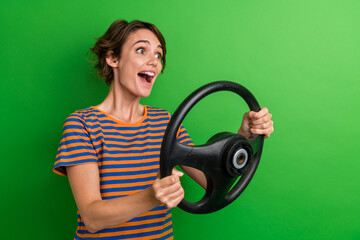 Canvas Print - Photo portrait of pretty young girl hold steering wheel driving dressed stylish striped outfit isolated on green color background