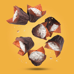 Wall Mural - Delicious muffins with powdered sugar falling on golden background