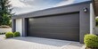 © Sandra - Modern black automatic garage door with sleek design and silver handle in front view, surrounded by clean white walls and a paved driveway.