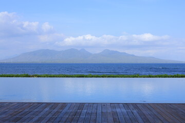 blue water at infinity pool. enjoying the view of sea and volcanic mountains in background. concept 