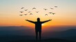 © Mnt - A person stands with outstretched arms against a sunset, surrounded by soaring birds, symbolizing freedom and connection to nature.