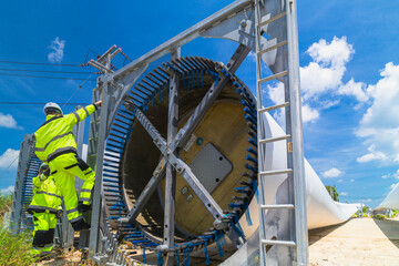 two engineers in safety gear inspecting a wind turbine blade section on a construction site. they ex