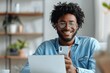 © btiger - Cheerful Young Entrepreneur Using Phone at Office Desk in Casual Attire