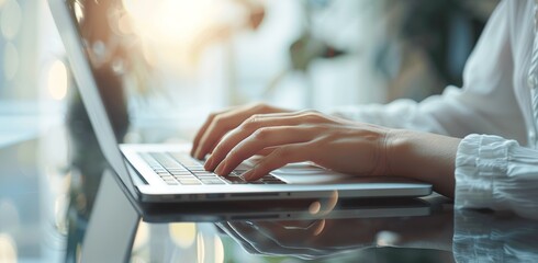 Professional woman's hands typing on laptop in office setting with digital tablet, remote work, online working concept
