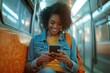 © FACTORY GRAPHICA  - Connected in Transit: A young woman, her face beaming with happiness, scrolls through her phone as she commutes on a subway train.
