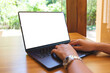 © Farknot Architect - Mockup image of a woman using and typing on laptop computer keyboard with blank white desktop screen on wooden table