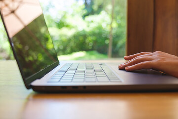 Wall Mural - Closeup image of a woman working and touching on laptop computer touchpad