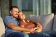 © Antonioguillem - Happy couple at sunset resting hugging on a couch in a terrace