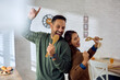 © Drazen - Carefree couple having fun and singing in kitchen.