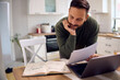 © Drazen - Smiling man reading motivation messages in his notebook while working at home.