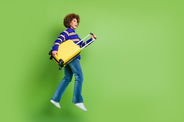 Canvas Print - Photo of cheerful glad woman wear blue striped trendy clothes hold valise baggage empty space isolated on green color background