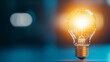 © Oatkhaphon - A glowing light bulb symbolizing innovation and bright ideas, set against a blurred background.