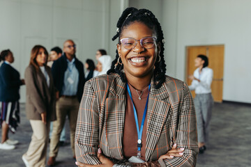 Wall Mural - confident businesswoman laughing at a conference in an office setting with colleagues in the backgro