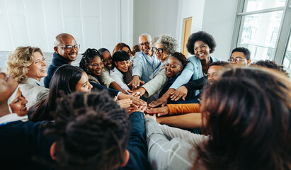 Wall Mural - diverse team of smiling people united in a group huddle showcasing unity and teamwork