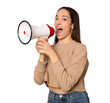 © Danko - Young smiling woman isolated over transparent background shouting through a megaphone to announce something