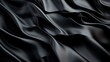 © Dulemegapixel - A close-up of smooth, flowing black silk fabric, featuring dramatic folds and ripples that convey a sense of elegance and luxurious texture in soft lighting.