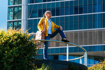 Beautiful senior businesswoman wearing business casual attire strolling in the city business district - Mature corporate female adult going to work at office