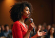 © PREM - A young African American woman speaks into a microphone, gesturing with her hand to show confidence and engagement