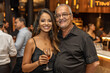 © Sascha - Brazilian woman with her father at an event, she is wearing black dress, smiling and holding cocktail glass, posing for camera, there's people dancing on background
