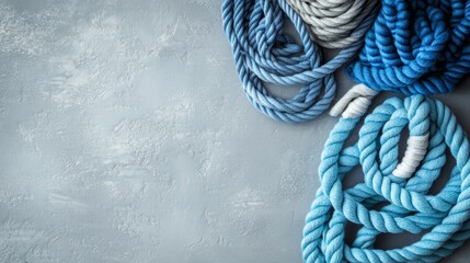 Wall Mural - Blue and light blue cotton ropes and cords are neatly arranged on a gray table. There's space for text.