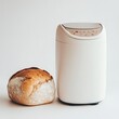 © Kavita - An innovative bread maker on a white background, with a loaf of bread beside it.