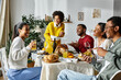 © LIGHTFIELD STUDIOS - A group of friends shares laughter and gratitude during a festive Thanksgiving dinner at home.