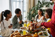 © LIGHTFIELD STUDIOS - A lively group of friends shares laughter and gratitude at a festive Thanksgiving meal.