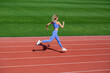 © Yevhen - Woman in sportswear jogging on stadium. Female jogger runner running outdoors, runner. Fitness woman on stadium. Young fitness woman runner running on stadium track.