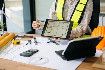 Wall Mural - businessman hand working and laptop with on on architectural project at construction site
