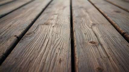 A close-up shot of weathered wooden planks, showcasing the natural grain, knots, and texture of the wood. The image is in focus on the planks in the foreground, with the background blurring out.