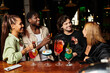 © LIGHTFIELD STUDIOS - A diverse group of young colleagues celebrates a successful project with drinks and laughter.