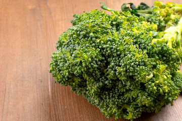 Raw fresh broccoli on old wooden table.