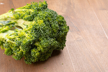 Raw fresh broccoli on old wooden table.