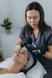 © Екатерина Лукашина - Cosmetologist performs a facial peeling procedure on a young woman.