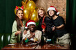 © LIGHTFIELD STUDIOS - Colleagues gather together, wearing festive attire and enjoying drinks during a lively celebration.