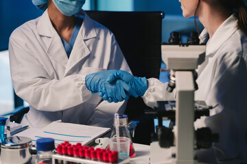 Wall Mural - team of biochemical research scientists working with a microscope for vaccine development