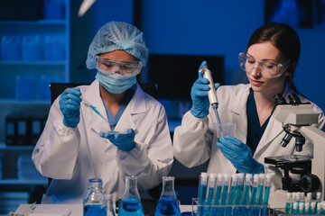 team of biochemical research scientists working with a microscope for vaccine development