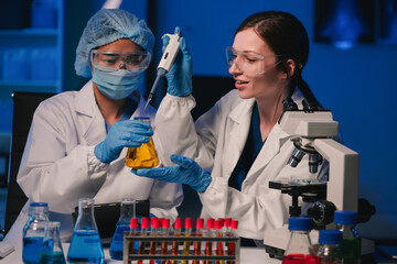 Wall Mural - team of biochemical research scientists working with a microscope for vaccine development