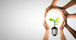 © Puttachat - Bulbs with seedling on soil. Earth day and earth day as group of diverse people joining to form hands connected together protecting the environment and promoting conservation and climate change issues