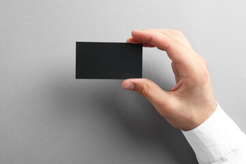 Poster - Woman with blank business card on grey background, closeup. Mockup for design