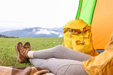 Sticker - Woman wearing trekking shoes and lying in tent outdoors, closeup