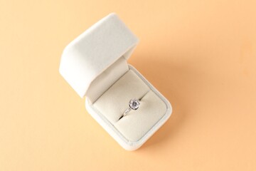 Poster - Beautiful ring with gemstone in box on beige background, top view