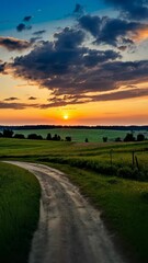 country road through fields at sunset with dramatic clouds, serene landscape view